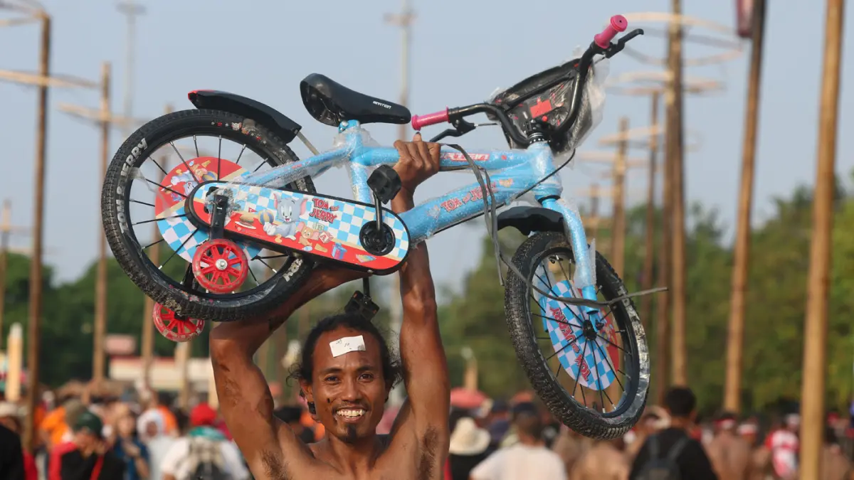 kemerihaan peserta saat mengikuti lomba panjat pinang memperingati Kemerdekaan Republik Indonesia di Beach Pool, Ancol, Jakarta, Senin (17/8/2026). (Dery Ridwansah/ JawaPos.com)