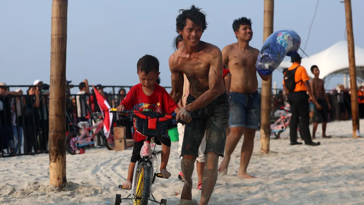 kemerihaan peserta saat mengikuti lomba panjat pinang memperingati Kemerdekaan Republik Indonesia di Beach Pool, Ancol, Jakarta, Senin (17/8/2026). (Dery Ridwansah/ JawaPos.com)