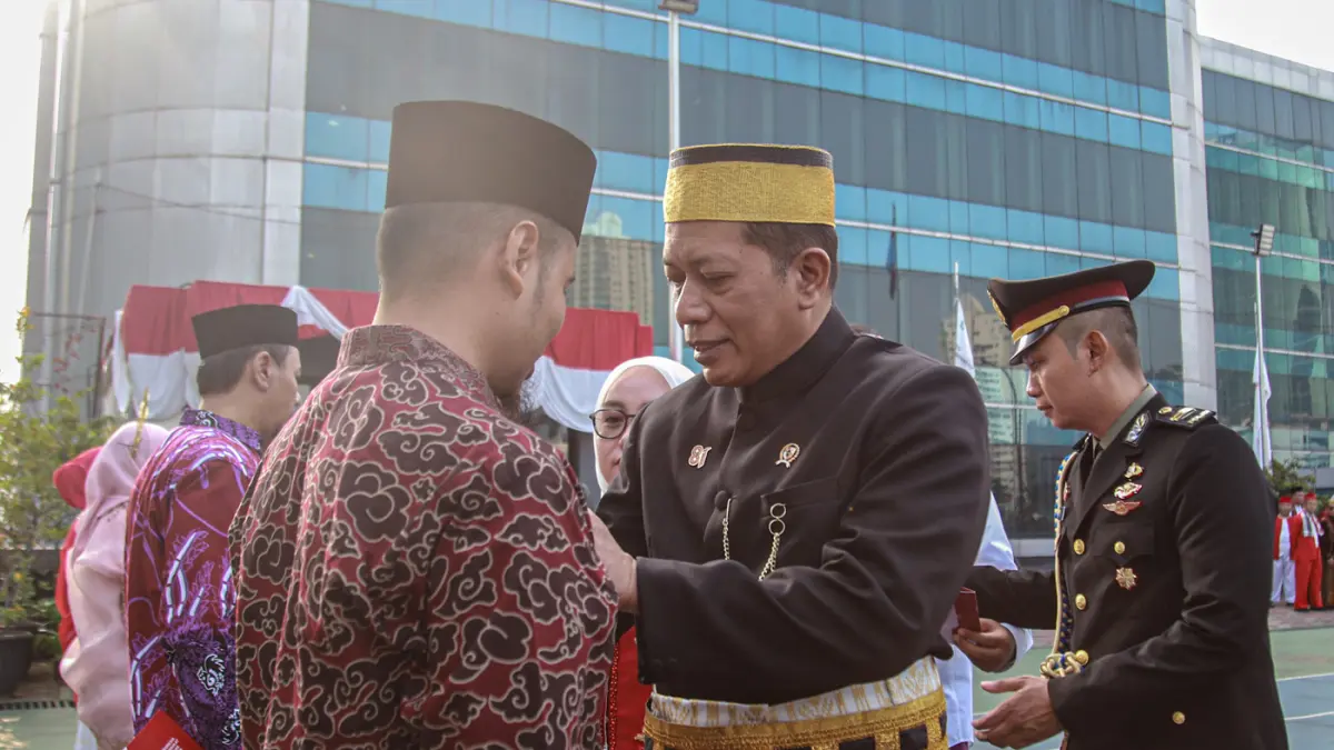 Menteri Koperasi (Menkop) Ferry Juliantono (kanan) menyerahkan penghargaan kepada pegawai Kemenkop saat upacara HUT ke-81 RI di Kantor Kementerian Koperasi (Kemenkop), Jakarta, Senin (17/08/2026). (Hanung Hambara/Jawa Pos)