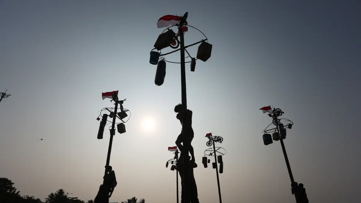 Peserta berusaha memanjat batang pinang saat mengikuti lomba memperingati Kemerdekaan Republik Indonesia di Beach Pool, Ancol, Jakarta, Senin (17/8/2026). (Dery Ridwansah/ JawaPos.com)