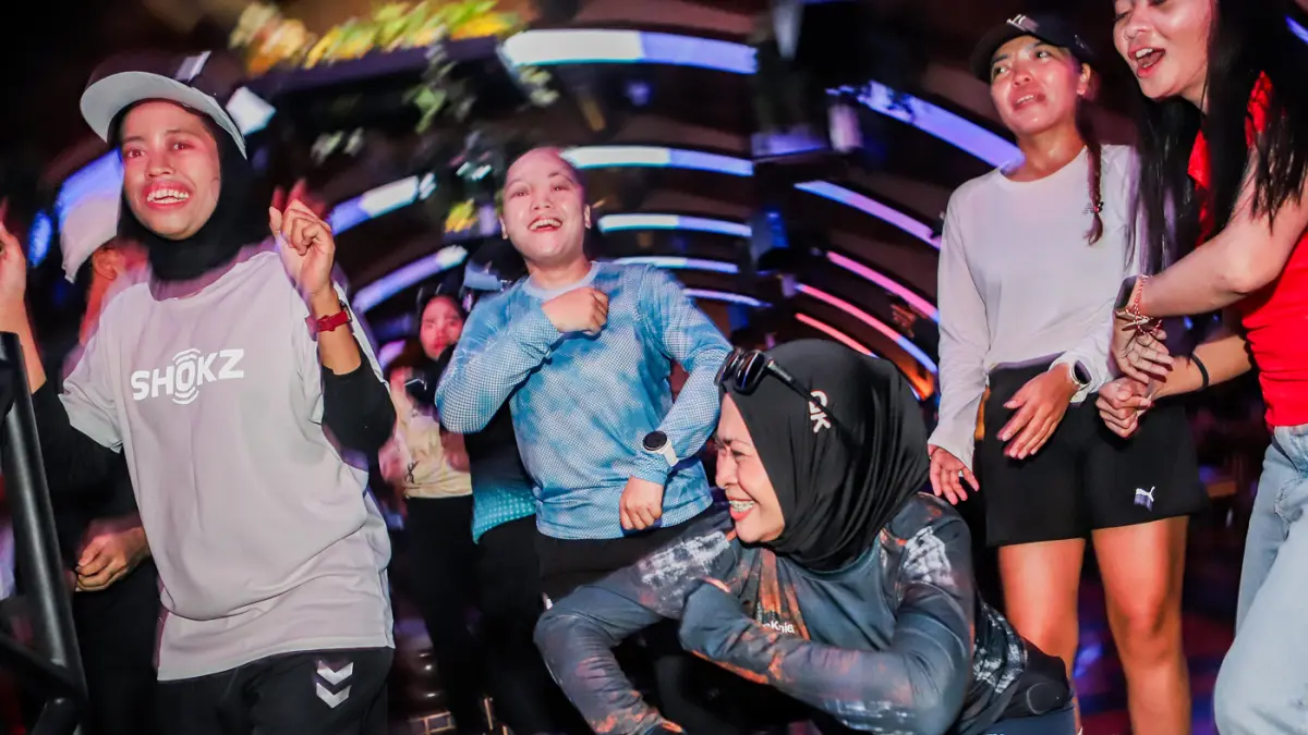 Sejumlah anggota komunitas lari di Surabaya menikmati alunan musik usai mengikuti fun run di salah satu social club dalam Suroboyo Mlayu Bengi di kawasan Tegalsari, Minggu (16/8) malam. (Riana Setiawan/Jawa Pos)