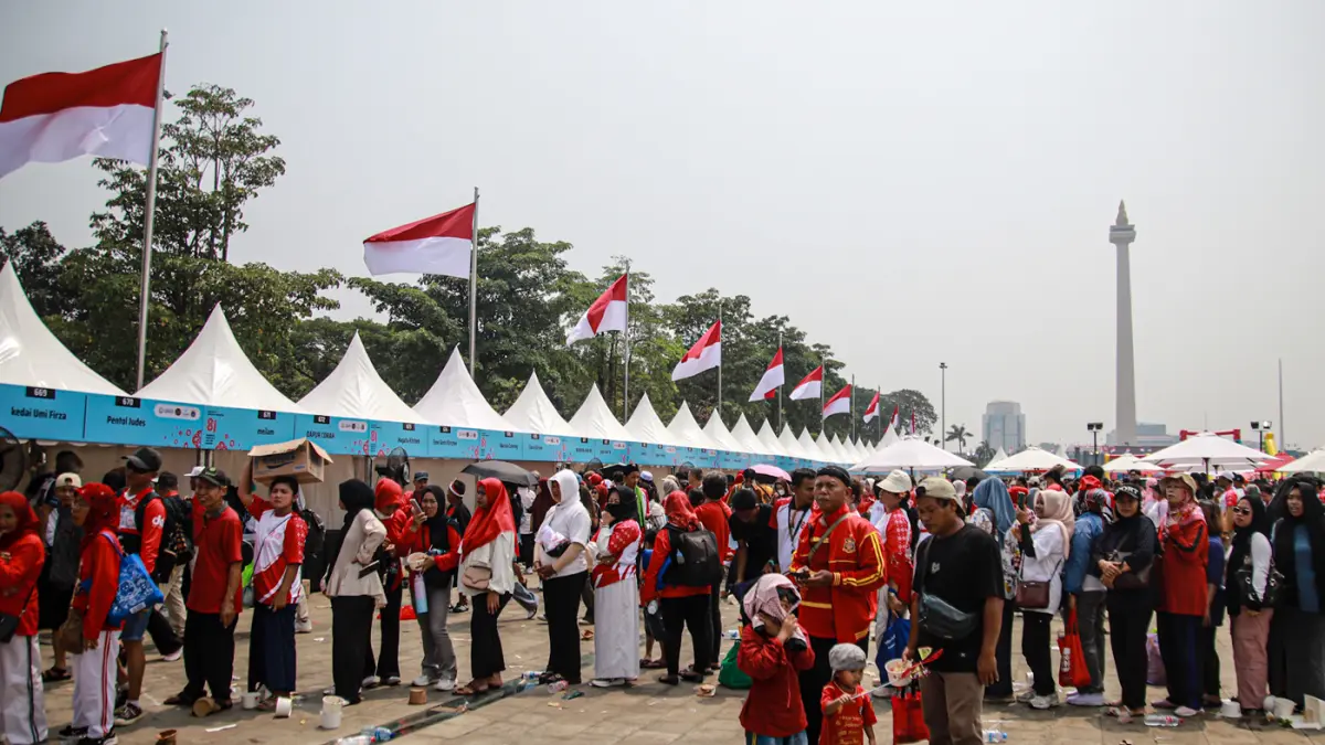 Sejumlah masyarakat bermain dan mengantri makanan dalam Pesta Rakyat dalam memeriahkan HUT ke-81 RI di Lapangan Monas, Jakarta, Senin (17/08/2026). (Hanung Hambara/Jawa Pos)