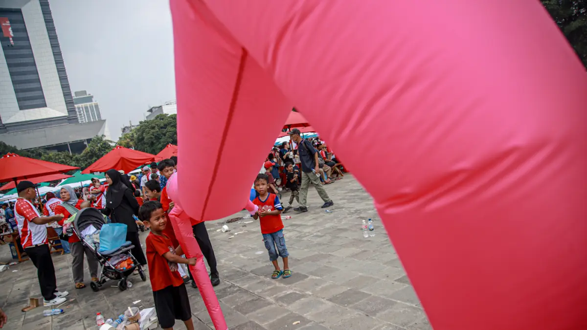 Sejumlah masyarakat bermain dan mengantri makanan dalam Pesta Rakyat dalam memeriahkan HUT ke-81 RI di Lapangan Monas, Jakarta, Senin (17/08/2026). (Hanung Hambara/Jawa Pos)