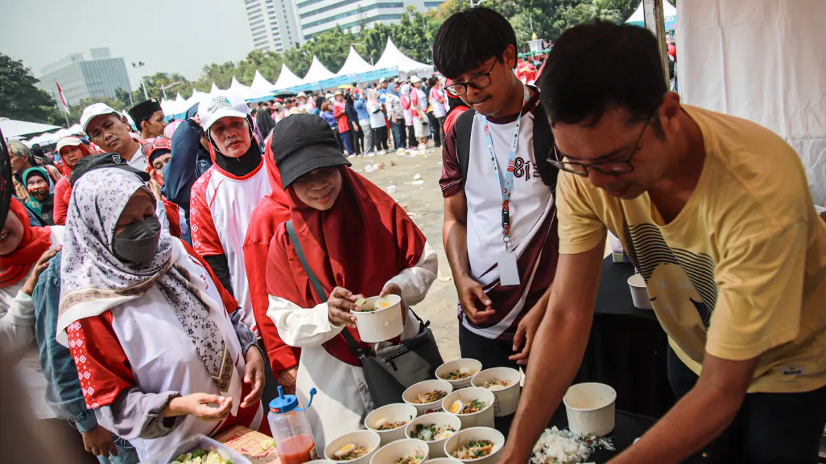 Sejumlah masyarakat bermain dan mengantri makanan dalam Pesta Rakyat dalam memeriahkan HUT ke-81 RI di Lapangan Monas, Jakarta, Senin (17/08/2026). (Hanung Hambara/Jawa Pos)