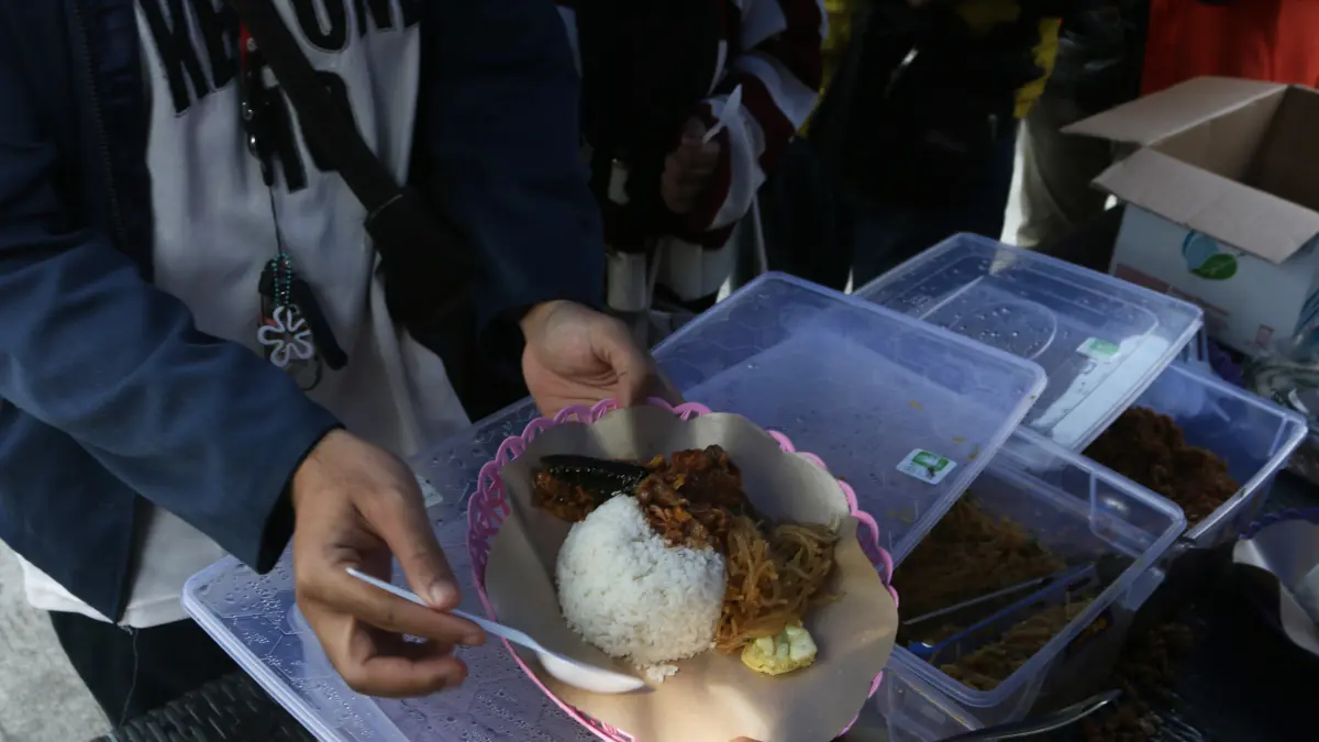 Warga antre untuk mendapatkan hidangan makanan dalam aksi sosial makan gratis bertajuk #BerawalDariKoin di kawasan Jalan Atmodirono Wonodri, Semarang, Jawa Tengah, Selasa (18/8/2026)