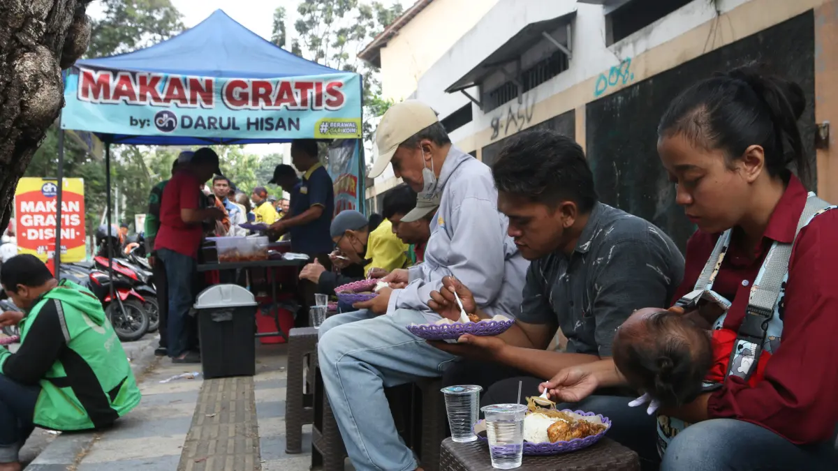 Warga menyantap hidangan makanan usai dibagikan gratis dalam aksi sosial makan gratis bertajuk #BerawalDariKoin di kawasan Jalan Atmodirono Wonodri, Semarang, Jawa Tengah, Selasa (18/8/2026)