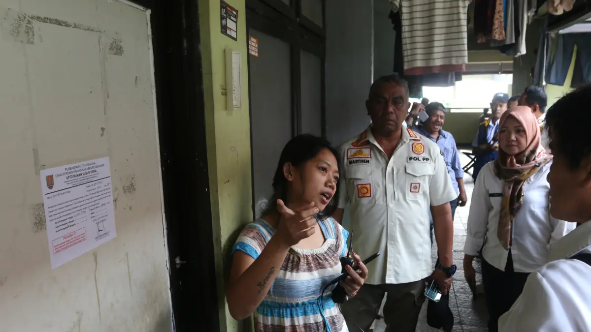 Petugas Satpol PP (kedua kanan) saat pemberitahuan penyegelan unit rumah susun sederhana sewa (rusunawa) kepada penghuni saat operasi yustisi di Rusunawa Kudu, Genuk, Semarang, Jawa Tengah, Rabu (19/8/2026)