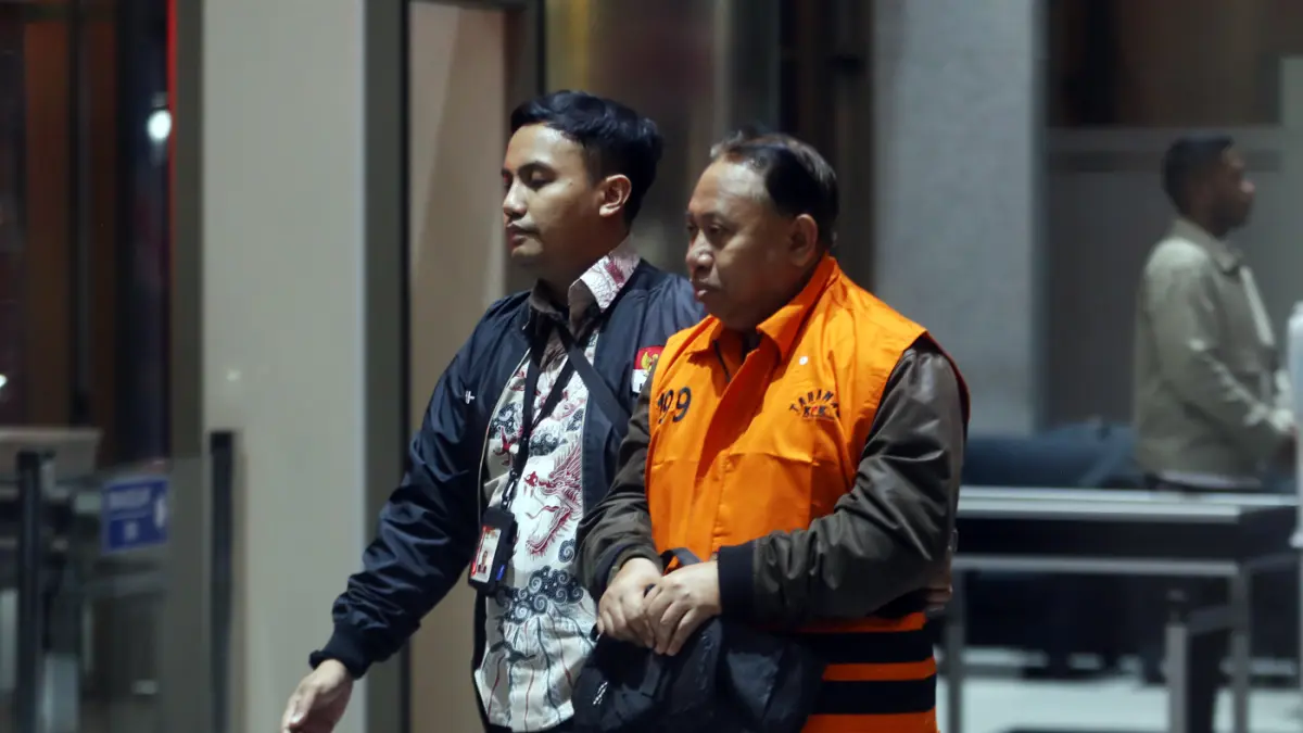 Rektor Universitas Jenderal Soedirman (Unsoed) Akhmad Sodiq berjalan menuju mobil tahanan seusai menjalani pemeriksaan di Gedung Merah Putih KPK, Jakarta, Sabtu (22/8/2026) dini hari. (Dery Ridwansah/ JawaPos.com)
