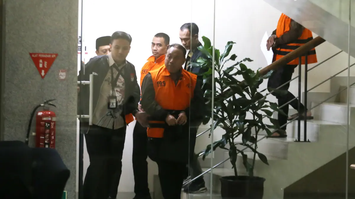 Rektor Universitas Jenderal Soedirman (Unsoed) Akhmad Sodiq dan Wakil Rektor Bidang Kemahasiswaan Norman Arie Prayogo berjalan menuju mobil tahanan seusai menjalani pemeriksaan di Gedung Merah Putih KPK, Jakarta, Sabtu (22/8/2026) dini hari. (Dery Ridwans