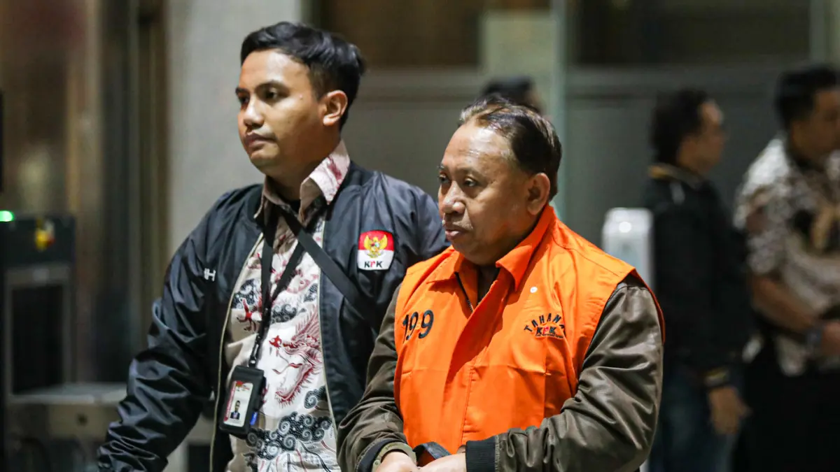 Rektor Universitas Jenderal Soedirman (Unsoed) Akhmad Sodiq berjalan menuju mobil tahanan seusai menjalani pemeriksaan di Gedung Merah Putih KPK, Jakarta, Sabtu (22/8/2026) dini hari. (Salman Toyibi/Jawa Pos)