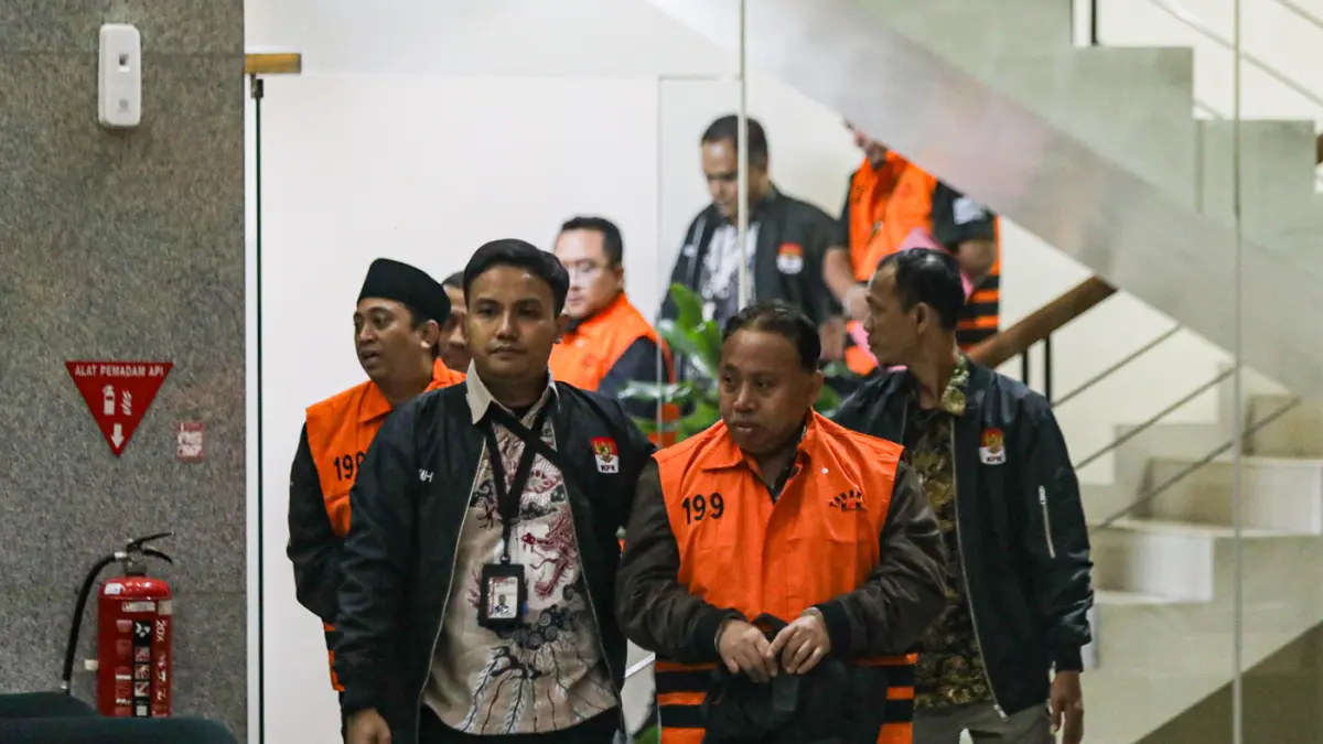 Rektor Universitas Jenderal Soedirman (Unsoed) Akhmad Sodiq berjalan menuju mobil tahanan seusai menjalani pemeriksaan di Gedung Merah Putih KPK, Jakarta, Sabtu (22/8/2026) dini hari. (Salman Toyibi/Jawa Pos)