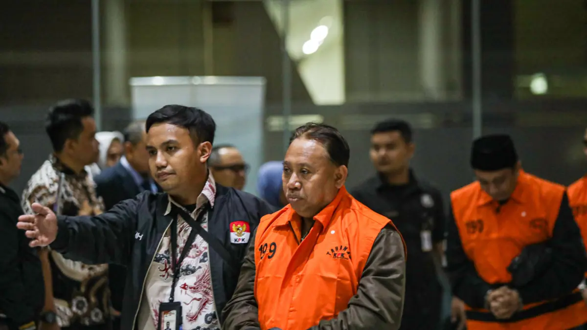 Rektor Universitas Jenderal Soedirman (Unsoed) Akhmad Sodiq berjalan menuju mobil tahanan seusai menjalani pemeriksaan di Gedung Merah Putih KPK, Jakarta, Sabtu (22/8/2026) dini hari. (Salman Toyibi/Jawa Pos)