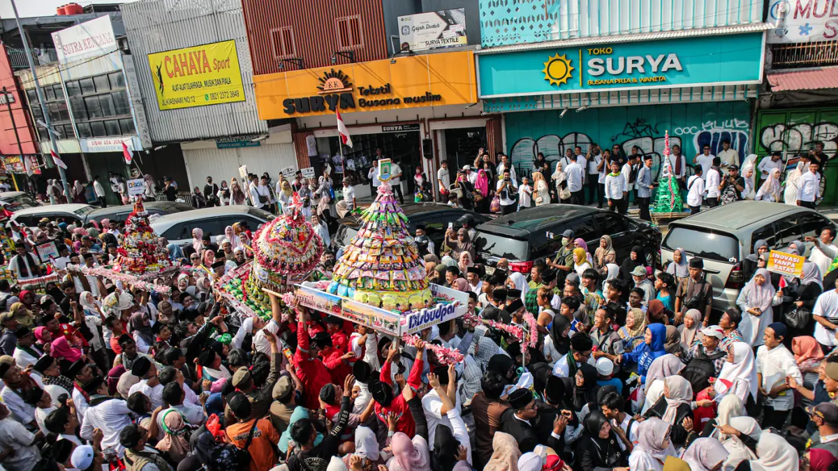 Sejumlah warga berebut gunungan yang diarak di acara Ngarak Perahu Maulid depan masjid Al-Ittihad, Kota Tangerang, Selasa (25/08/2026). (Hanung Hambara/Jawa Pos)