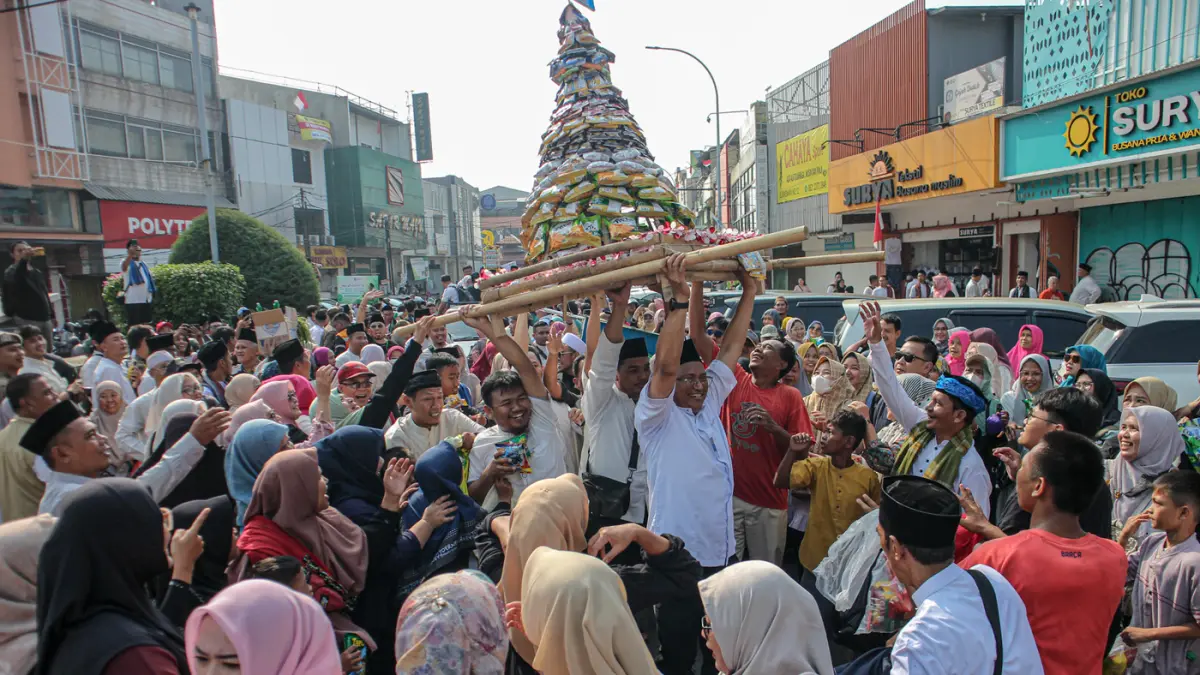Sejumlah warga berebut gunungan yang diarak di acara Ngarak Perahu Maulid depan masjid Al-Ittihad, Kota Tangerang, Selasa (25/08/2026). (Hanung Hambara/Jawa Pos)
