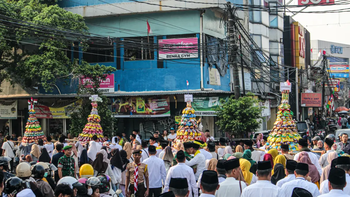 Warga mengarak beragam gunungan berisi hasil bumi dan makanan ringan di acara Ngarak Perahu Maulid depan masjid Al-Ittihad, Kota Tangerang, Selasa (25/08/2026). (Hanung Hambara/Jawa Pos)