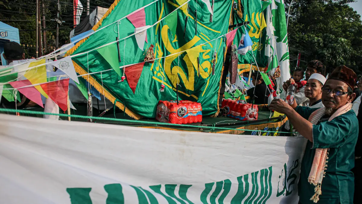 Warga mengarak beragam gunungan berisi hasil bumi dan makanan ringan di acara Ngarak Perahu Maulid depan masjid Al-Ittihad, Kota Tangerang, Selasa (25/08/2026). (Hanung Hambara/Jawa Pos)
