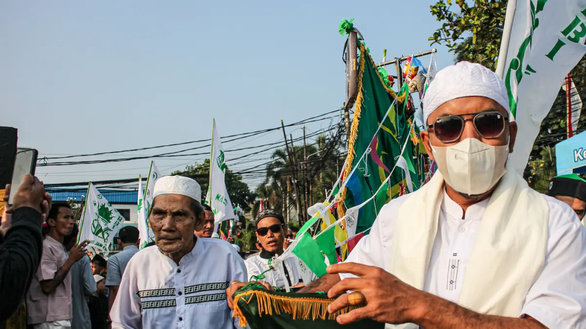 Warga mengarak beragam gunungan berisi hasil bumi dan makanan ringan di acara Ngarak Perahu Maulid depan masjid Al-Ittihad, Kota Tangerang, Selasa (25/08/2026). (Hanung Hambara/Jawa Pos)