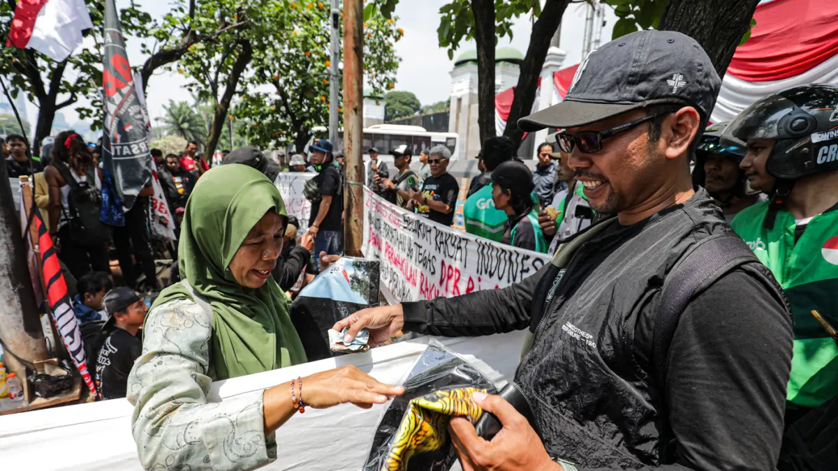 Warga membeli baju yang di jual Warga Pati dari Aliansi Masyarakat Pati Bersatu (AMPB) di depan Kompleks Parlemen, Senayan, Jakarta, Rabu (26/8/2026). (Salman Toyibi/Jawa Pos)