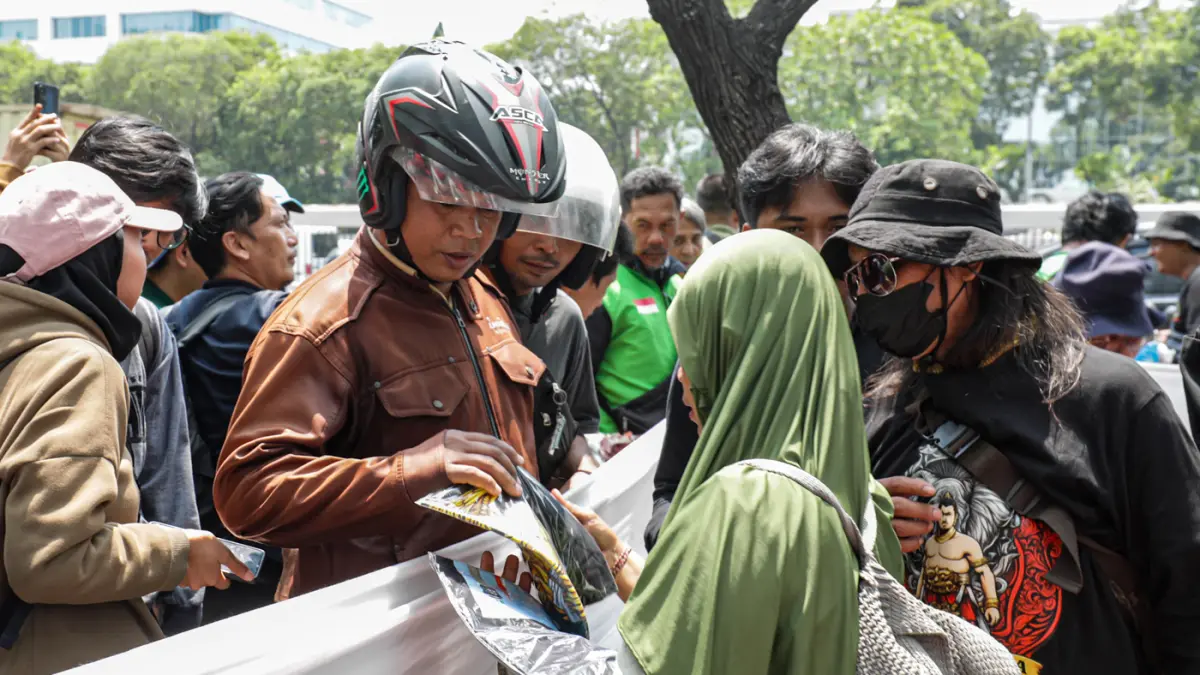 Warga membeli baju yang di jual Warga Pati dari Aliansi Masyarakat Pati Bersatu (AMPB) di depan Kompleks Parlemen, Senayan, Jakarta, Rabu (26/8/2026). (Salman Toyibi/Jawa Pos)