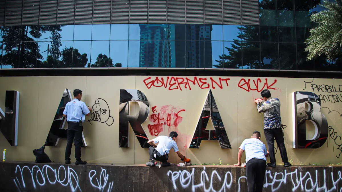 Pegawai Bank BNI membersihkan tembok yang terkena vadalisme usai demo kemarin di Menara BNI Pejompongan, Jalan Penjernihan, Jakarta, Jumat (28/08/2026). (Hanung Hambara/Jawa Pos)