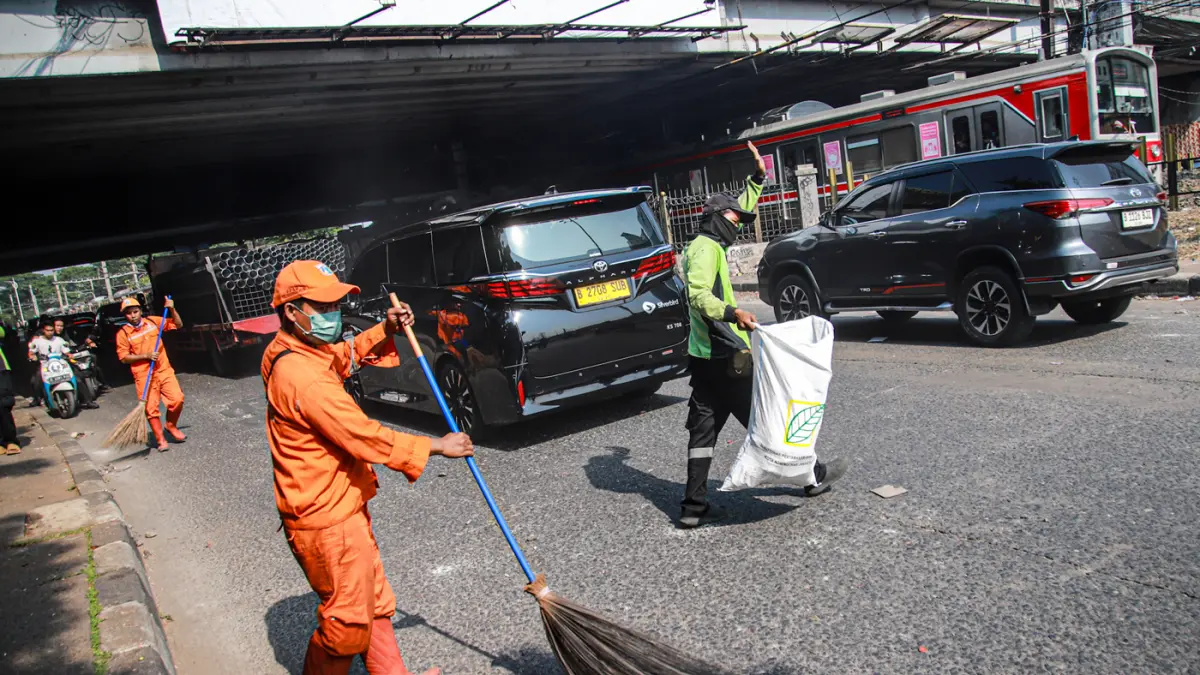 Sejumlah Anggota PPSU membersihkan sisa batu serta sampah sisa demo lainnya di Jalan Penjernihan, Jakarta, Jumat (28/08/2026). (Hanung Hambara/Jawa Pos)