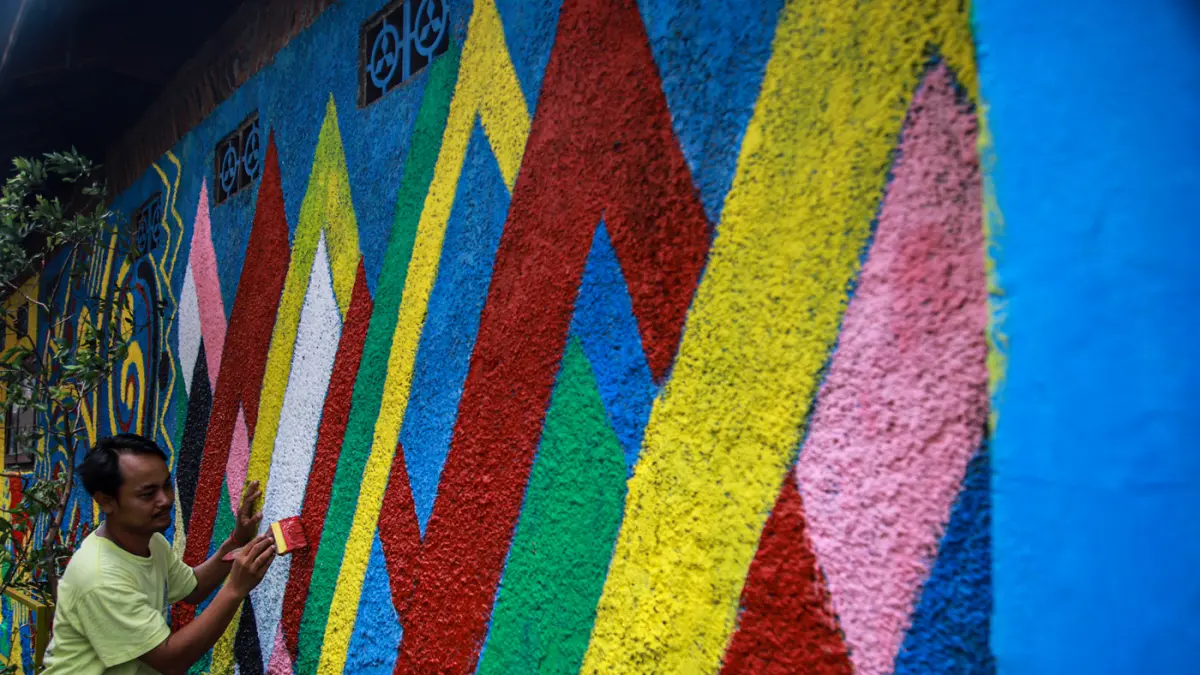 Sejumlah Penanganan Prasarana dan Sarana Umum (PPSU) melukis mural di Jalan Kali Pasir, Cikini, Jakarta, Rabu (26/08/2026). (Hanung Hambara/Jawa Pos)
