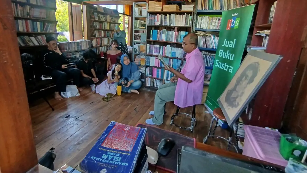 Sastrawan Andy SW (kanan) membacakan Surabaya karya Idrus di JBS. (Diar Candra/JawaPos.com) - Image