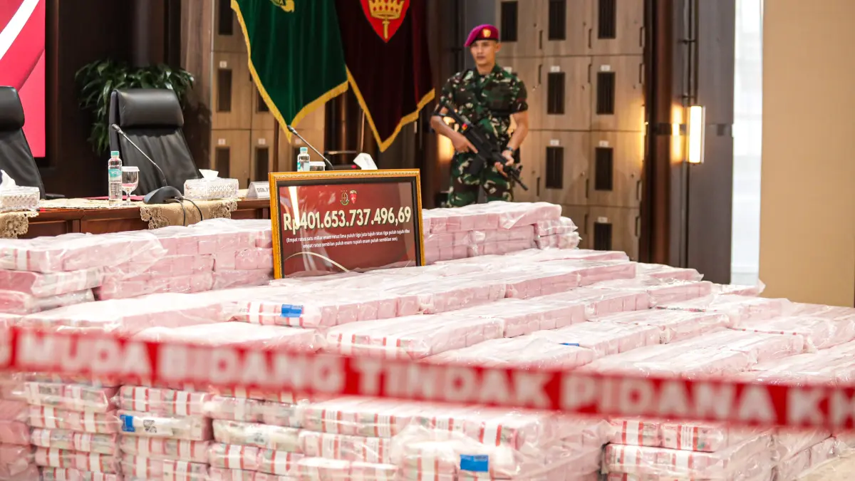 Patugas berjaga di dekat barang bukti kasus dugaan korupsi tata kelola nikel saat konferensi pers di Gedung Bundar, Kejaksaan Agung, Jakarta, Senin (31/8/2026). (Salman Toyibi/Jawa Pos)