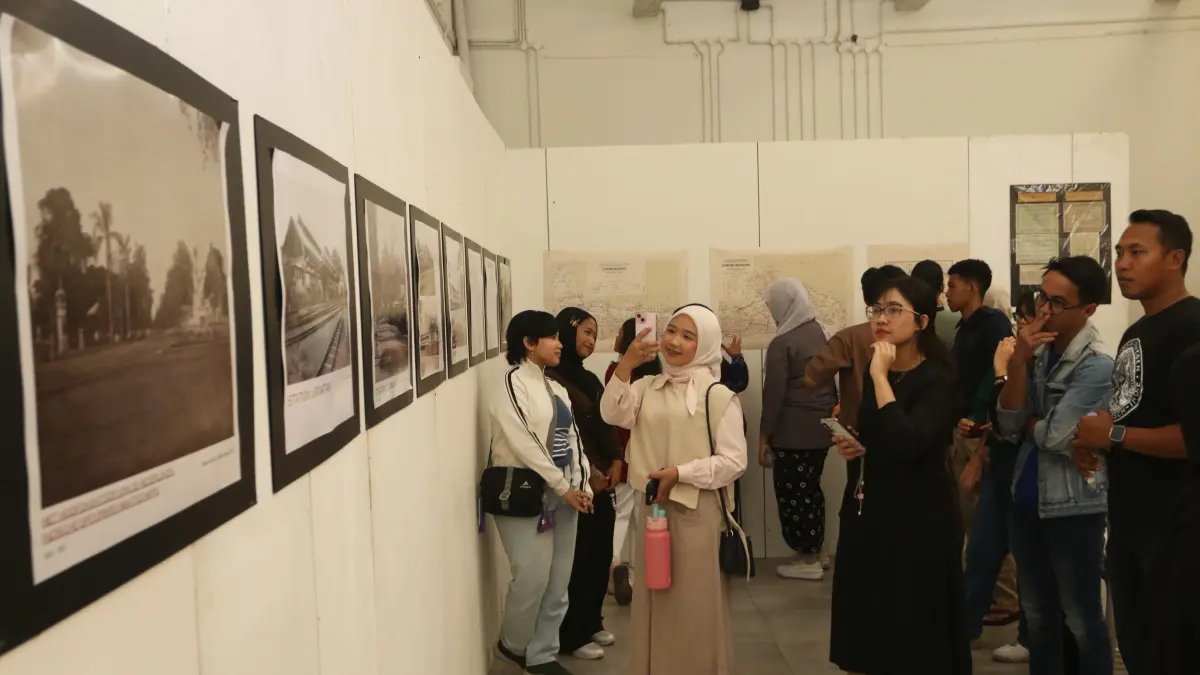 Pengunjung melihat karya foto dalam pameran arsip 159 tahun perjalanan kereta api pertama di Indonesia di Rumah Pohan, Semarang, Jawa Tengah, Minggu (30/8/2026). (Nur Chamim/Jawa Pos Radar Semarang)