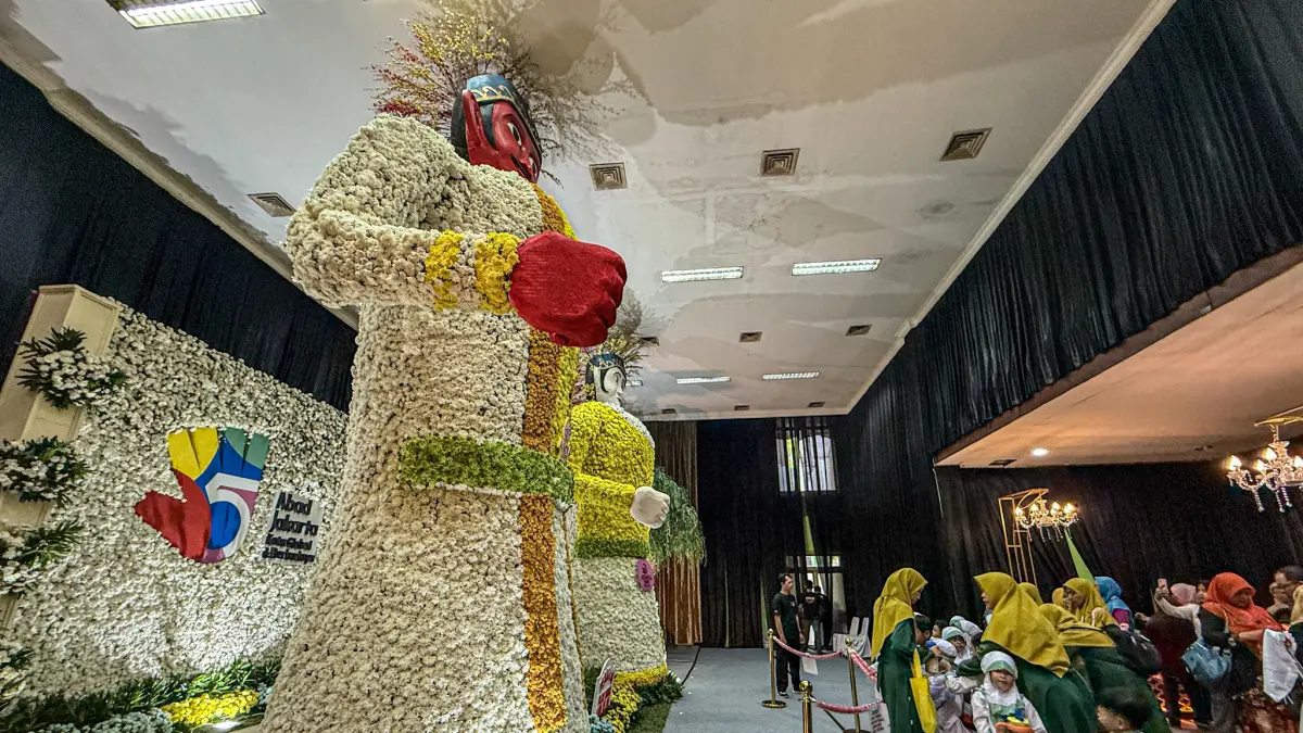 Pengunjung melihat ondel-ondel raksasa yang terbuat dari rangkaian bunga aster di Gebyar Bunga di Pasar Bunga Rawa Belong, Jakarta, Jumat (04/09/2026)