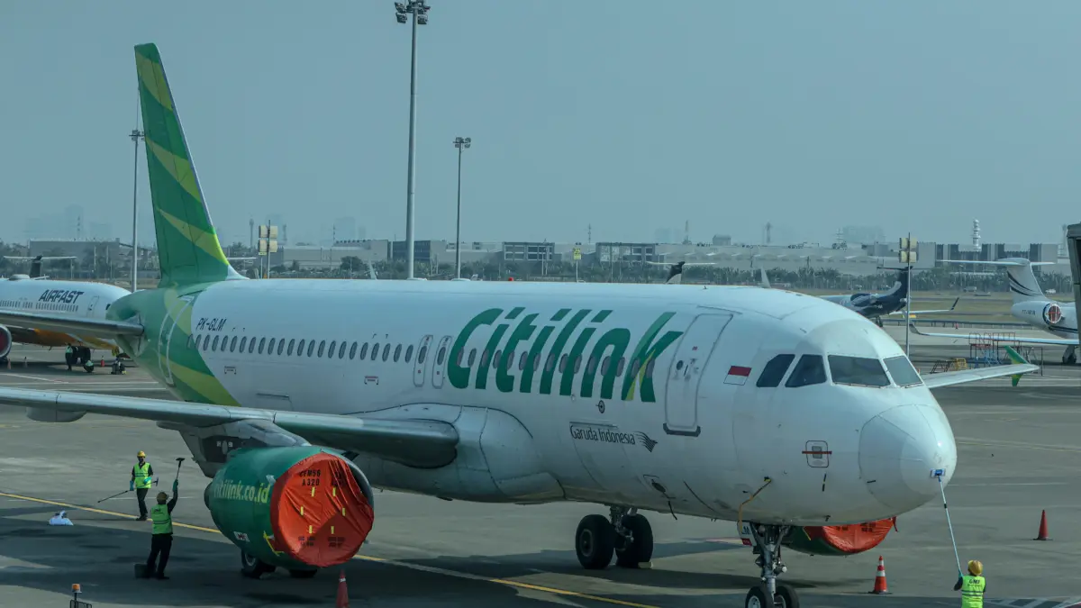 Sejumlah kru darat membersihkan badan pesawat dari paparan partikel abu vulkanik di Bandara Soekarno-Hatta, Tangerang, Senin (07/09/2026). (Hanung Hambara/ Jawa Pos)