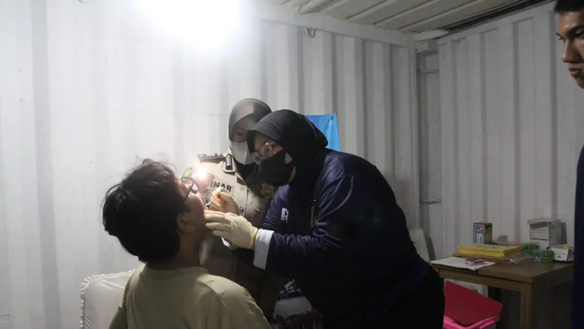 Anak dari jurnalis Arie Basuki yang hilang kontak, Arvian Mesianik Putra (tengah) berjalan keluar usai proses pengambilan sampel DNA di Pos Ante Mortem DVI Polda Banten, Carita, Pandeglang, Banten, Senin (14/9/2026).