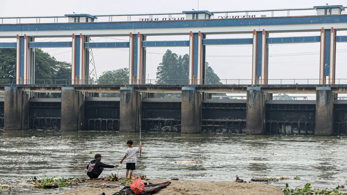 Sejumlah warga memancing di sekitar Bendungan Pasar Baru atau Pintu Air Sepuluh di Kota Tangerang, Minggu (20/09/2026).(Hanung Hambara/ Jawa Pos)