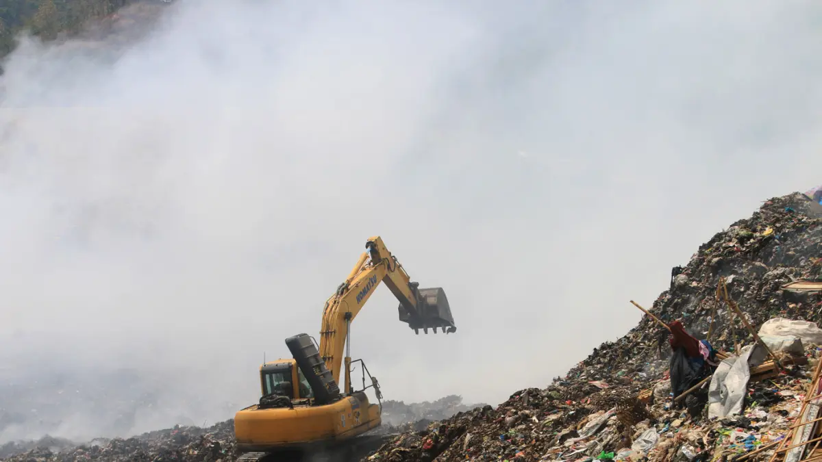 Petugas Dinas Lingkungan Hidup Kota Semarang memadamkan titik api menggunakan ekskavator di Tempat Pemrosesan Akhir (TPA) Jatibarang, Semarang, Jawa Tengah, Kamis (1/10/2026). (Nur Chamim/Jawa Pos Radar Semarang)