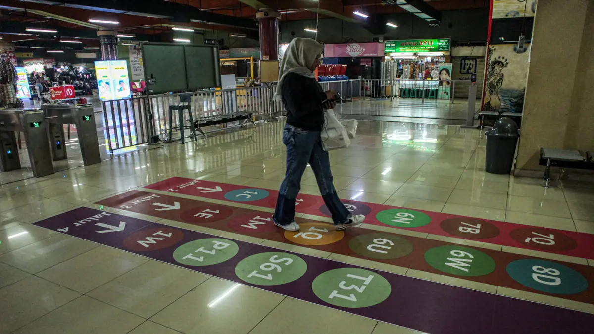 Sejumlah calon penumpang moda transportasi melintas diatas jalur pemandu rute atau (Wayfinding) di Terminal Blok M, Jakarta, Rabu (30/09/2026). (Hanung Hambara/ Jawa Pos)