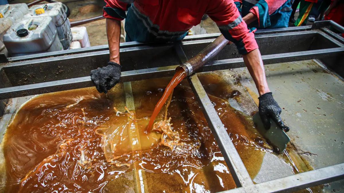Sejumlah pekerja menampung dan mengolah minyak goreng bekas di TUkR Harapan Indah, Bekasi, Senin (28/09/2026). (Hanung Hambara/Jawa Pos)