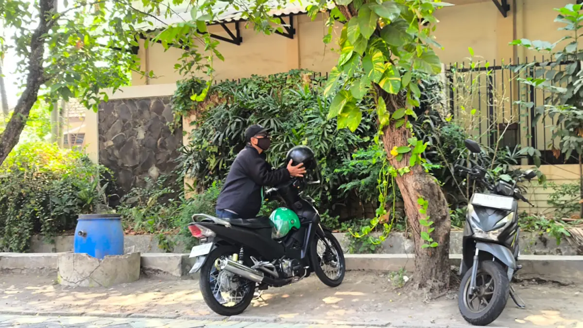 Driver ojek online (Ojol) Moh. Jaelani (52) bersiap berangkat menjemput penumpang. (Dadang Kurnia/ JawaPos.com)