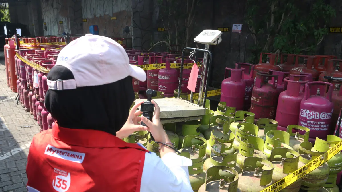 Penyidik berada di dekat barang bukti tabung elpiji tiga kilogram saat rilis pengungkapan tindak pidana di bidang minyak dan gas bumi (migas) serta mineral dan batu bara (minerba) di Ditreskrimsus Polda Jawa Tengah, Semarang, Jawa Tengah, Jumat (16/10/202