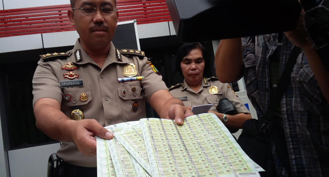 RUGIKAN NEGARA: Polisi menunjukkan materai palsu buatan RR yang sangat mirip dengan aslinya. - Image