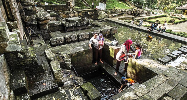 RITUAL SEGAR: Pengunjung pemandian Jolotundo, Trawas, Mojokerto membasuh diri. Patirtan ini terbilang paling suci dan paling tua di kawasan timur Jawa. - Image