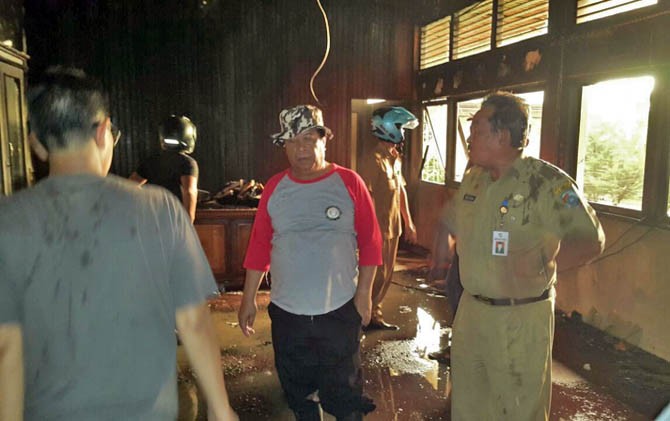 Wakil Bupati Mempawah, Gusti Ramlana (kaos abu-abu merah) dan Sekda Mohrizal (baju dinas) melihat kondisi ruang kerjanya yang ludes dilahap api, Senin (23/1) sore. - Image
