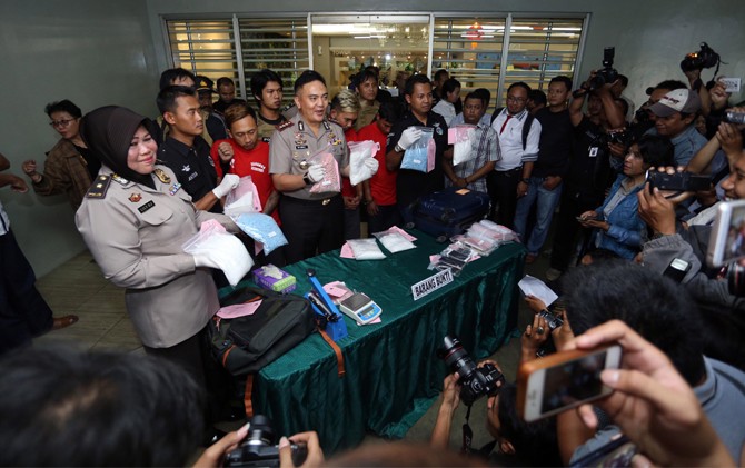 BERSAMA TERSANGKA: Kapolrestabes Surabaya Kombespol M. Iqbal menunjukkan barang bukti dan tersangka pada Selasa (17/1) di area apartemen. - Image