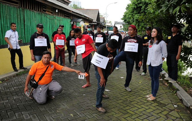 BERANINYA KEROYOKAN: Tersangka Farid Maulana (kaus merah depan) memperagakan adegan menendang korban M. Djohan Arifin alias Ipin. - Image
