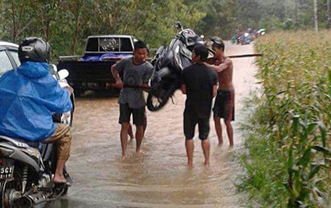 Banjir Semidang, Desa Suka Maju mengakibatkan arus transportasi Singkawang-Bengkayang lumpuh total dan kendaraan roda dua terpaksa dipikul warga, Senin (13/2). - Image