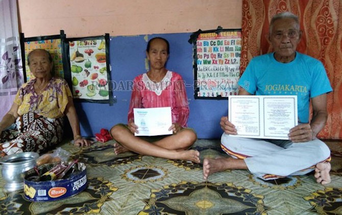 BOLEH PERCAYA BOLEH TIDAK: Isay Djudae (kanan) saat menunjukan cetakan undangan pernikahan Pangkalima Burung dengan Sri Baruno Parameswari di rumahnya Desa Telok Kecamatan Katingan Tengah, Rabu (22/2). - Image