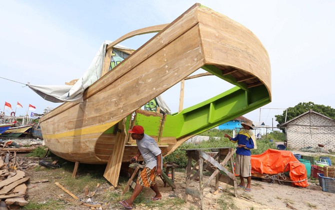 ANDALAN: Perajin kapal kayu di Kecamatan Panceng terus berproduksi. - Image