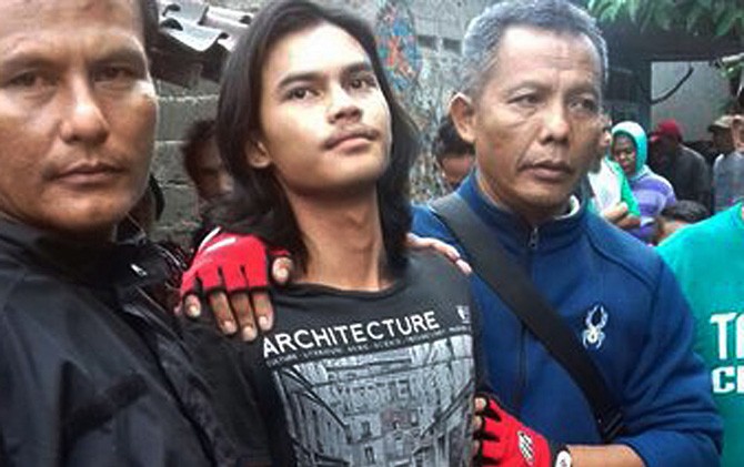Dimas, 18 (tengah) pembunuh ibu kandung saat diamankan polisi. - Image