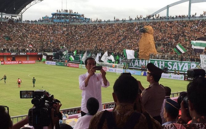 Presiden Joko Widodo melakukan selfie dengan latar koreografi suporter PSS di Stadion Maguwoharjo, Sabtu 4/2). - Image