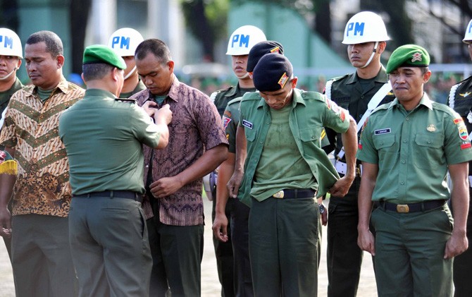 Kasdam I/Bukit Barisan Brigjen TNI Tiopan Aritonang (kiri) menanggalkan seragam anggota TNI pada upacara pemberhentian tidak dengan hormat (PTDH), di Medan, Jumat (17/2). - Image