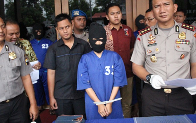 DIDUGA GELAPKAN UANG: Murvianti Tsabita, debt collector perusahaan otomotif di Kudus (bertopeng) saat gelar perkara di Mapolres Kudus, Jumat (10/2) - Image